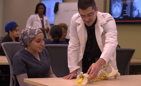 Student with an instructor looking at a dorsal spine